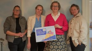 Medewerkers van Talma Urk nemen cheque in ontvangst voor subsidie Veerkracht en Zeggenschap