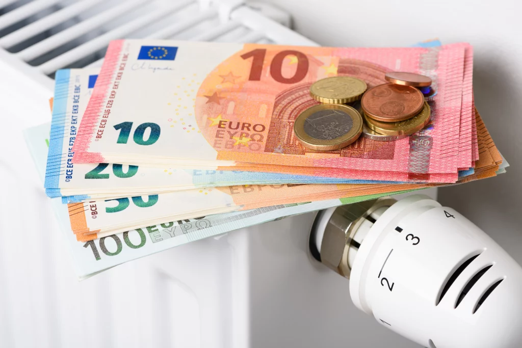 Afbeelding met verwarmingsknop, radiator, briefgeld en losse euro's ten behoeve van de teruggave energiebelasing